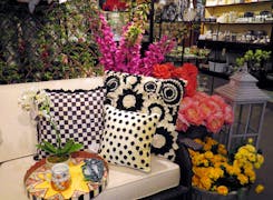 Household furnishings and tall, colorful floral arrangements coexist on our showroom floor